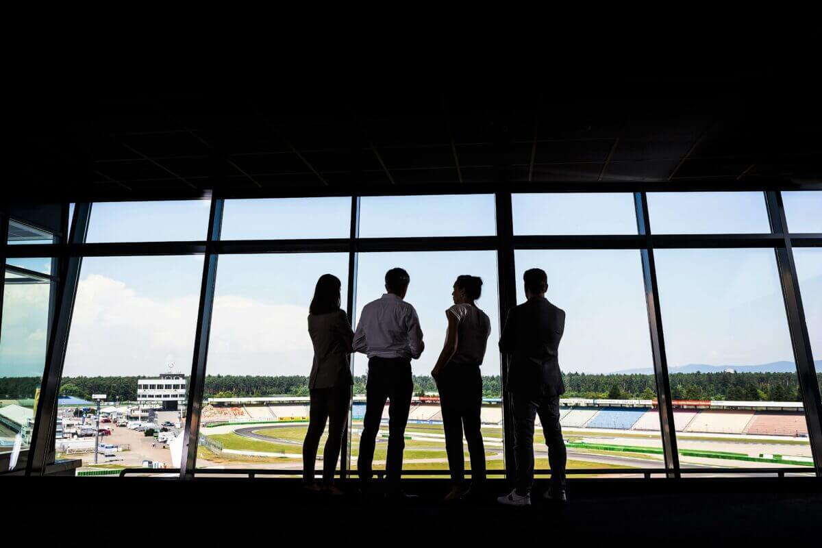 Das Team der e4 Qualification GmbH in ihrem Räumlichkeiten mit Blick auf den Hockenheimring